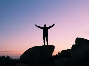 Person waving hands during sunset