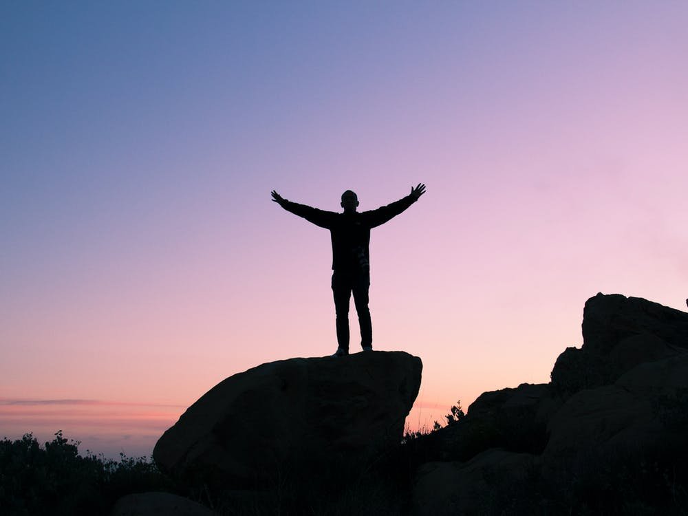 Person waving hands during sunset