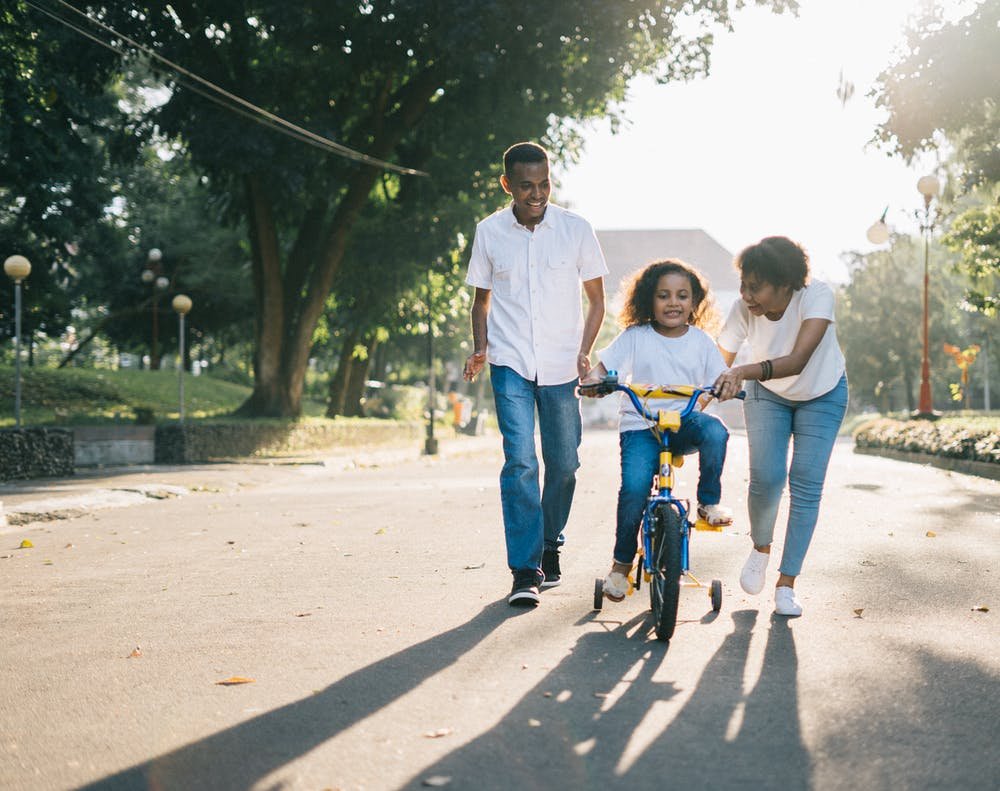 kid parents teaching kid riding cycle