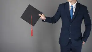 business man is holding graduation hat, business education concept