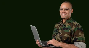 A soldier in uniform using a laptop