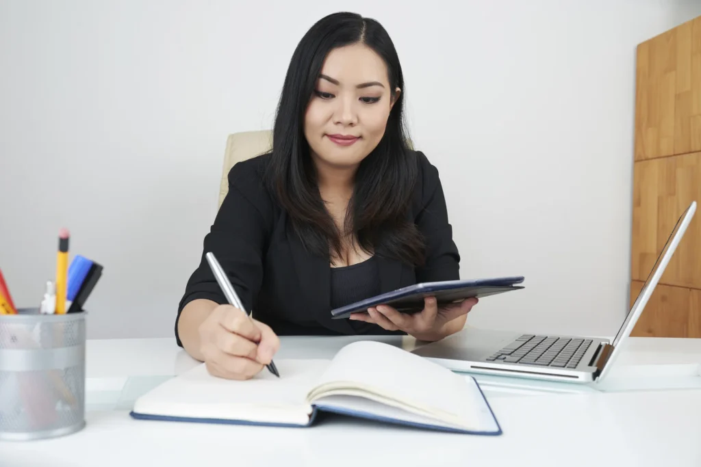 Student writing MBA essay at desk.